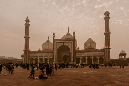 Free A bustling scene at Jama Masjid, Delhi, showcasing Mughal architecture at dusk with a lively crowd. Stock Photo