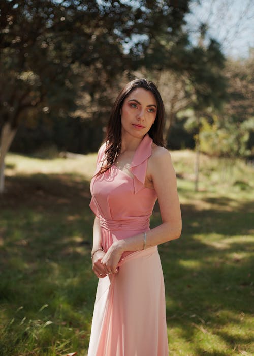 Gorgeous Brunette Woman in Pink Dress Posing in Garden