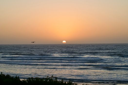 Breathtaking sunset over the Atlantic Ocean in Cape Town, showcasing a vivid sky and gentle waves.