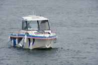 A motorboat labeled 'Bateau Ecole' traveling on the sea in Dinard, Bretagne, France.