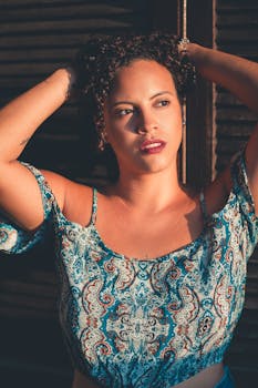 一位卷发红唇的时尚女性穿着露脐上衣在户外摆姿势