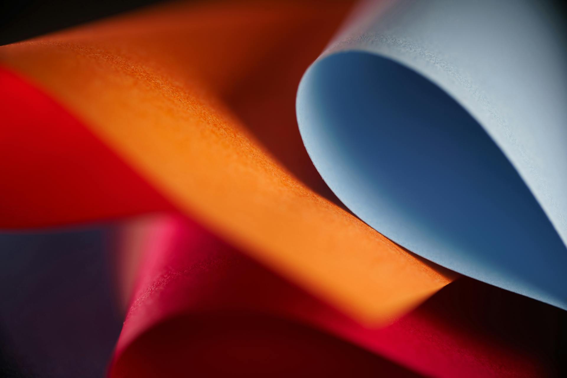 Vibrantly colored paper rolls creating a dynamic abstract composition with rich textures.