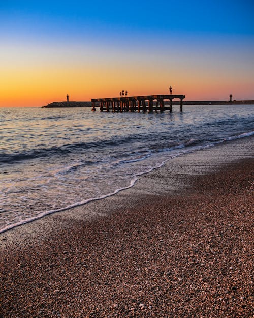 Tourists on a Fragment of an Old Pier in the Sea