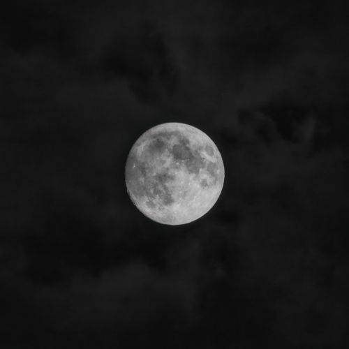 Free A mesmerizing full moon shines through a cloudy night sky over Nelson, WI. Stock Photo