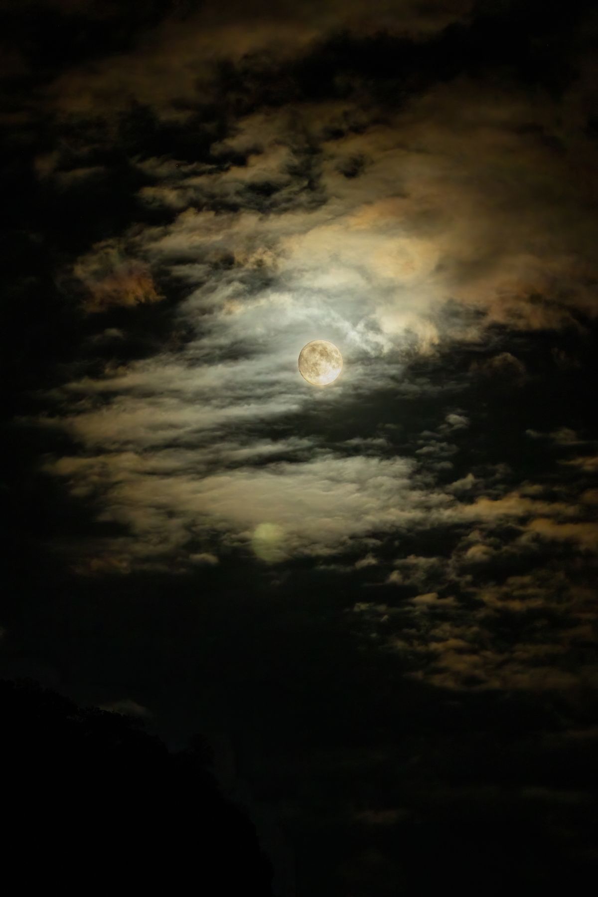 A full moon glowing over a calm night sky