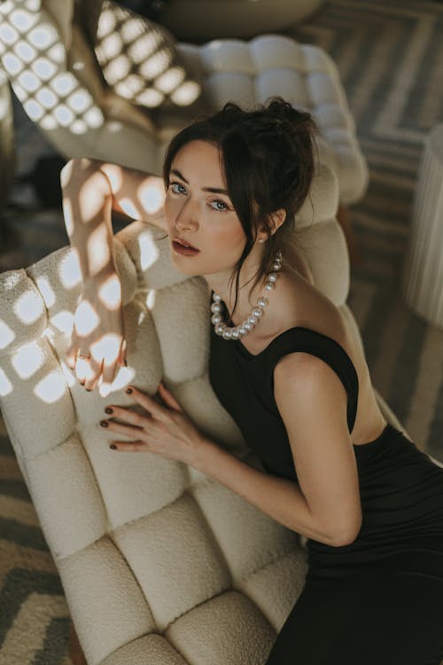 A woman in a black dress sitting on a chair