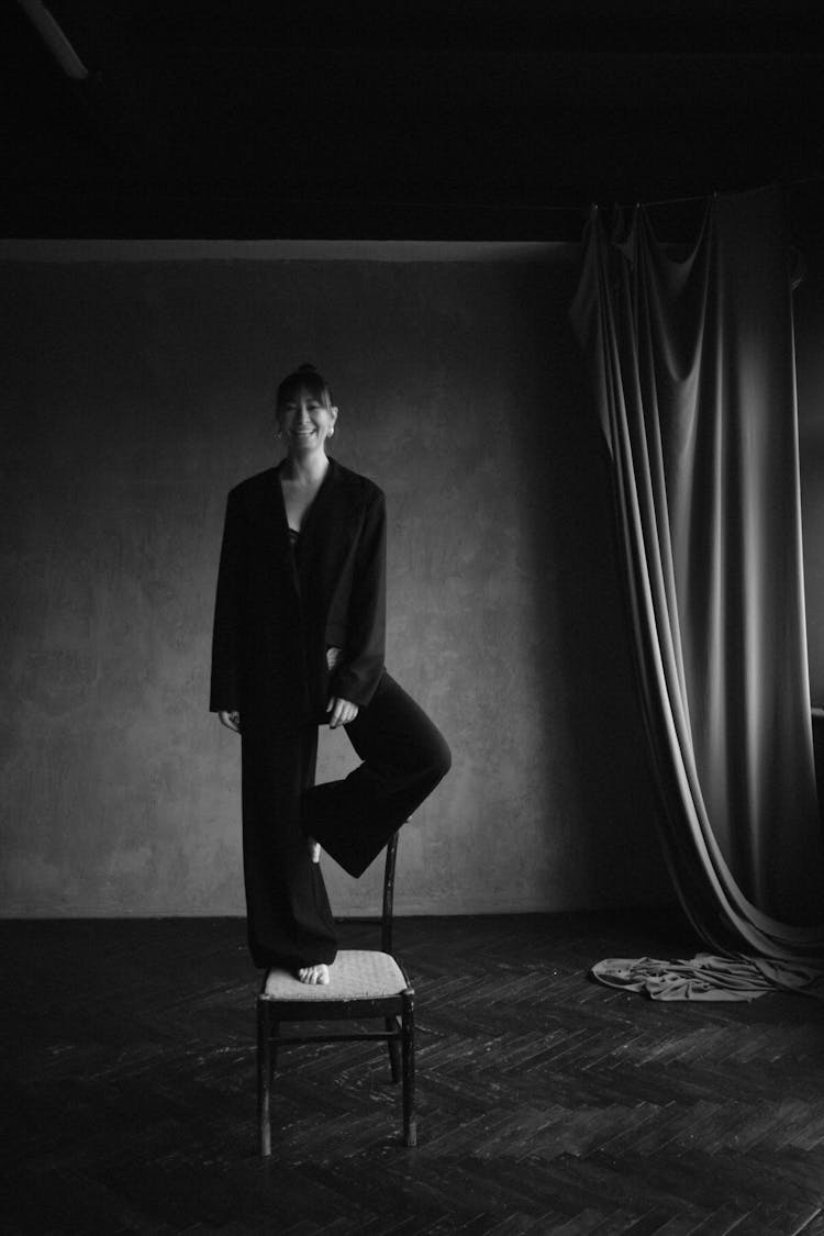 Barefoot Woman In Black Standing On Chair