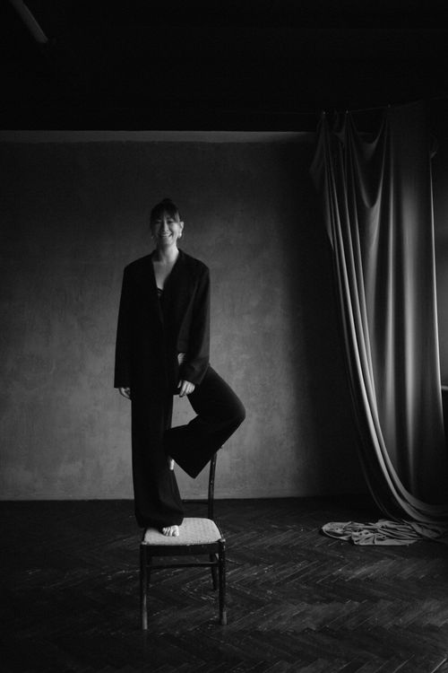 Free Artistic black and white portrait of a woman standing on a chair indoors. Stock Photo