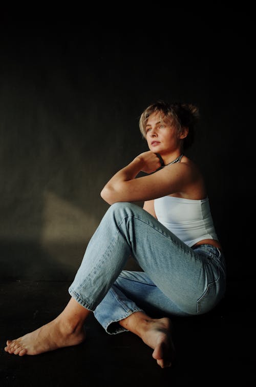 A woman sitting on the floor in jeans