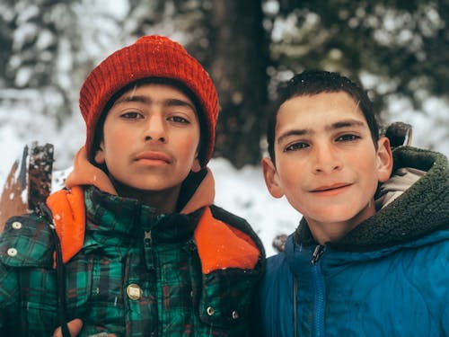 Two Boys in Jackets Standing Outside in Winter 