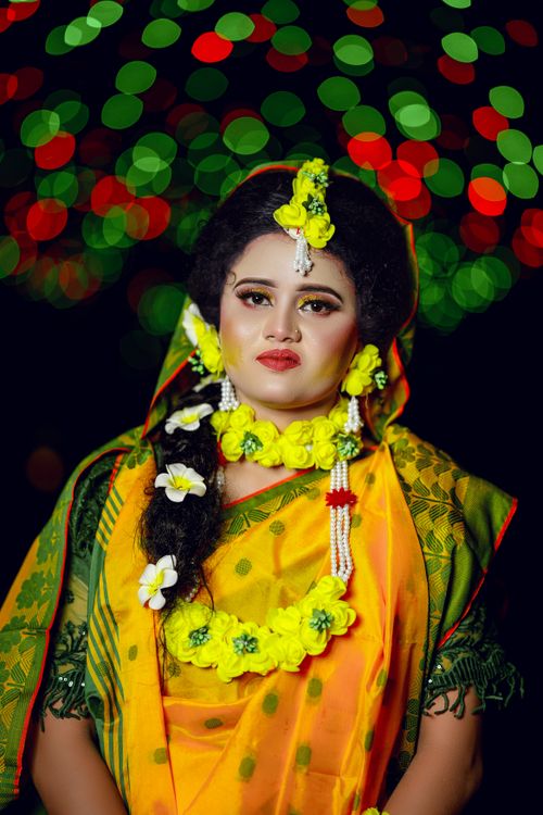 Free Elegant portrait of a South Asian woman in traditional attire and floral jewelry, with bokeh lights. Stock Photo