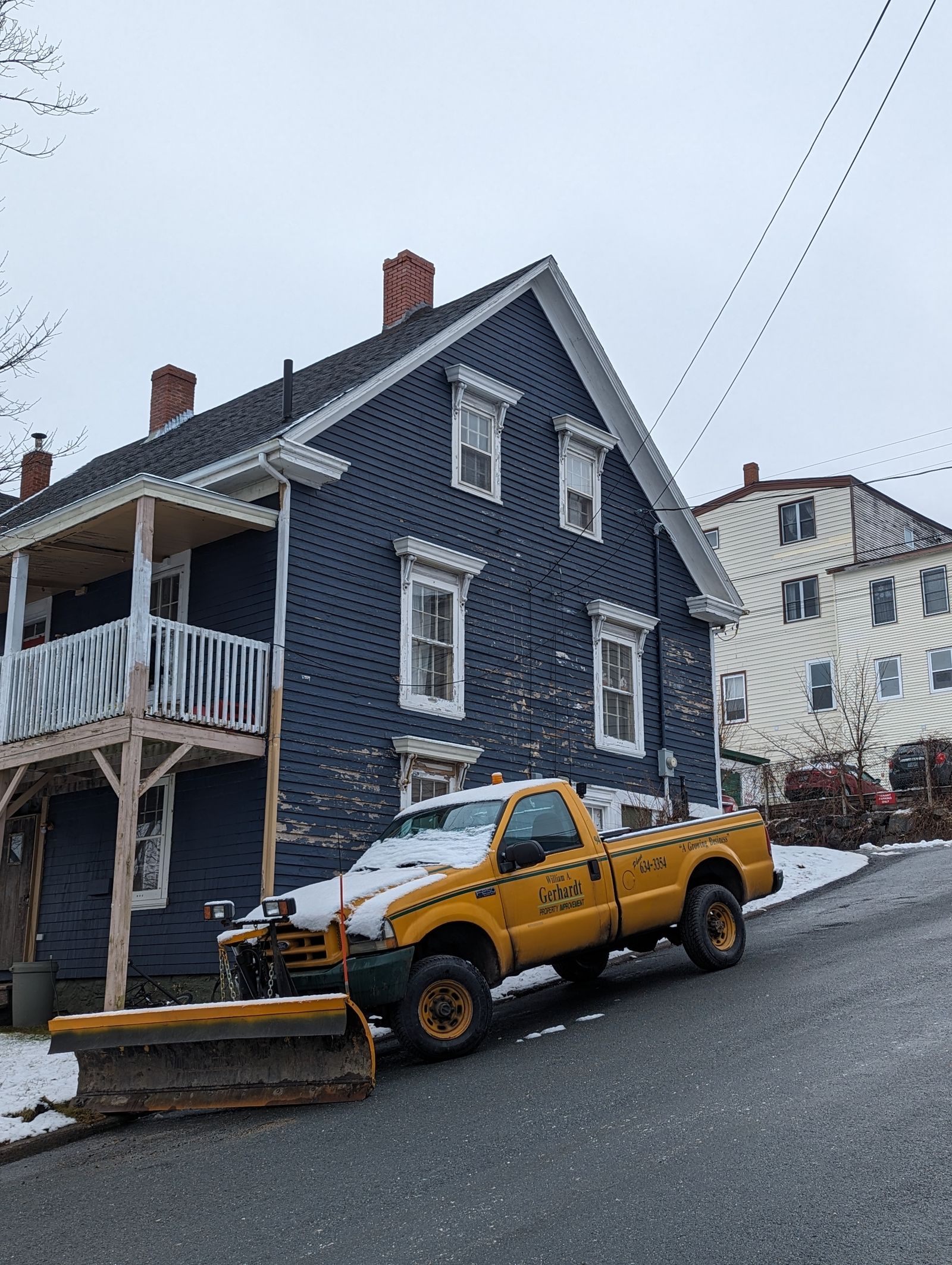 Pickup truck with snow plow clearing a snowy residential street