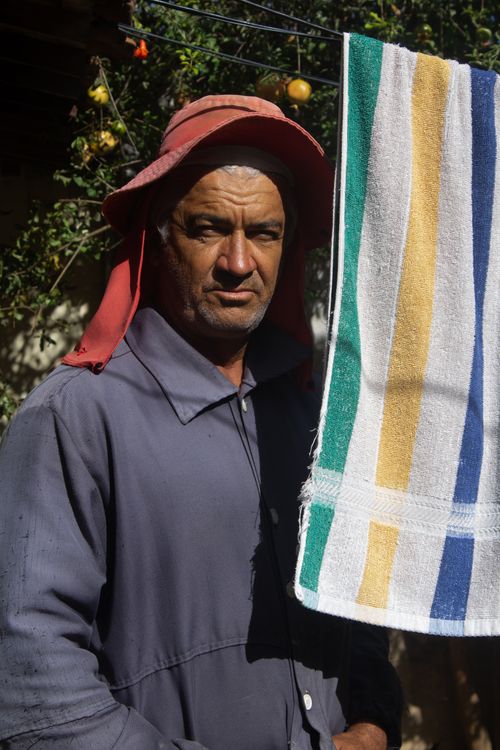 Free Elderly man standing outdoors with a colorful towel drying in sunlight. Stock Photo