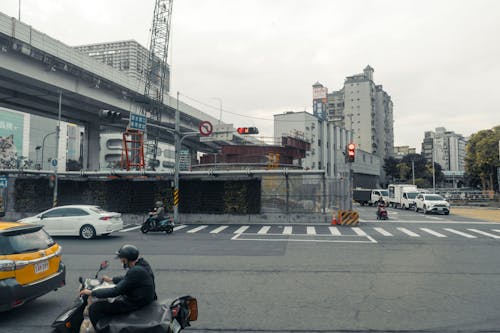 A man on a motorcycle is riding down a street