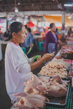 Woman browsing fresh meat at a bustling urban bazaar.