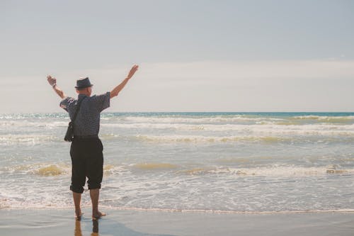 Tourist Raising Arms at Beach