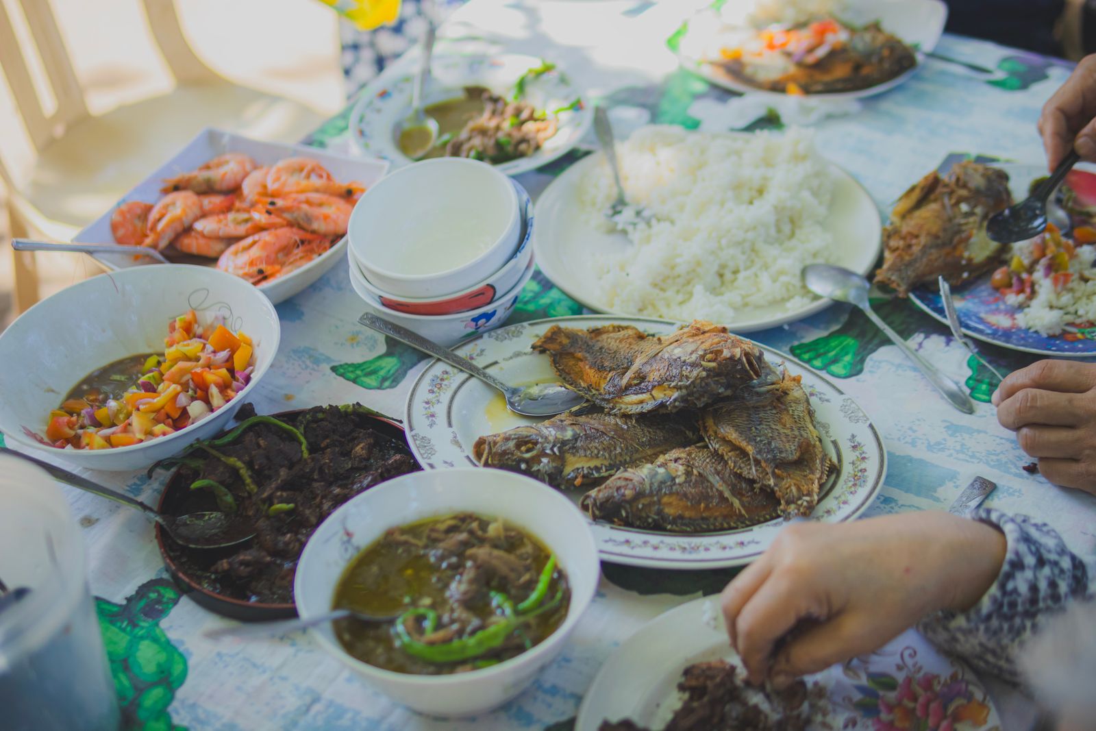 Enjoy a homemade seafood dinner with rice and vibrant side dishes, perfect for shared meals.