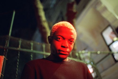 Free Close-up urban portrait at night with red lighting, featuring a young man in a street setting. Stock Photo