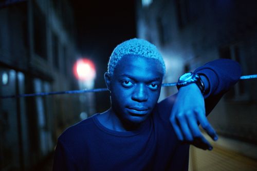 Free A man in blue light poses confidently during a night street photoshoot. Stock Photo