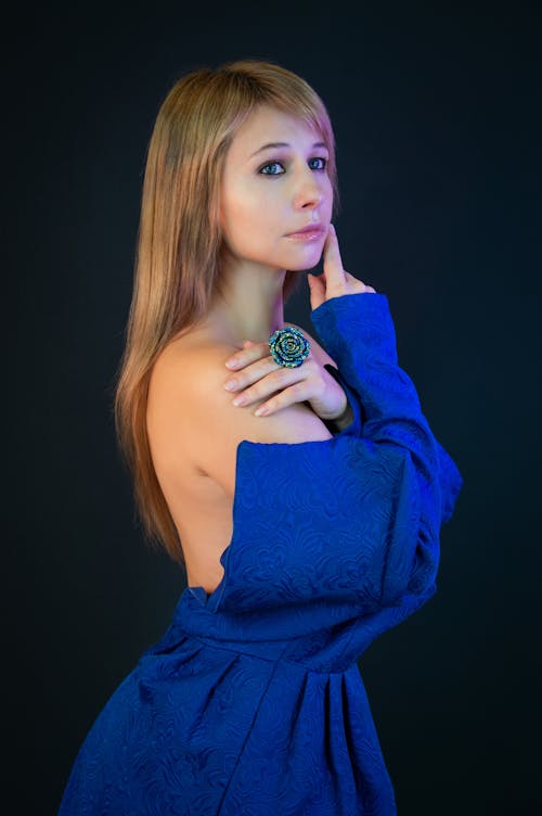 A beautiful woman in blue dress posing for the camera