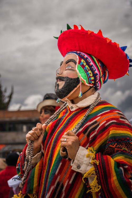 A man in colorful clothing with a mask on his face