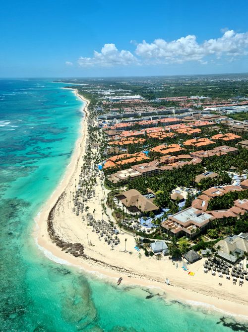 Free Breathtaking aerial view of Punta Cana's turquoise coast and resort-lined shoreline. Stock Photo
