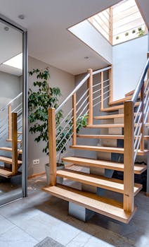 Contemporary interior design featuring a stylish wooden staircase under a skylight.