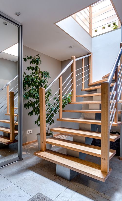 Free Contemporary interior design featuring a stylish wooden staircase under a skylight. Stock Photo