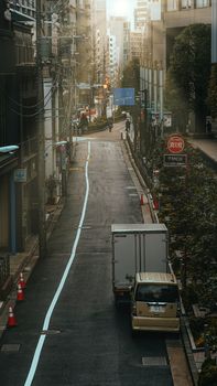 A tranquil urban street in Tokyo with cars and buildings, capturing a typical Japanese city vibe.
