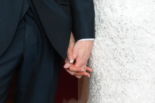 Free Close-up of a bride and groom holding hands on their wedding day. Stock Photo