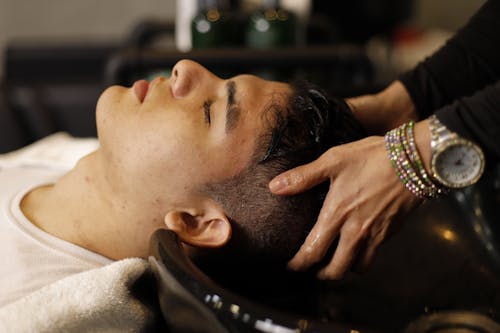 A man getting his hair cut at a salon