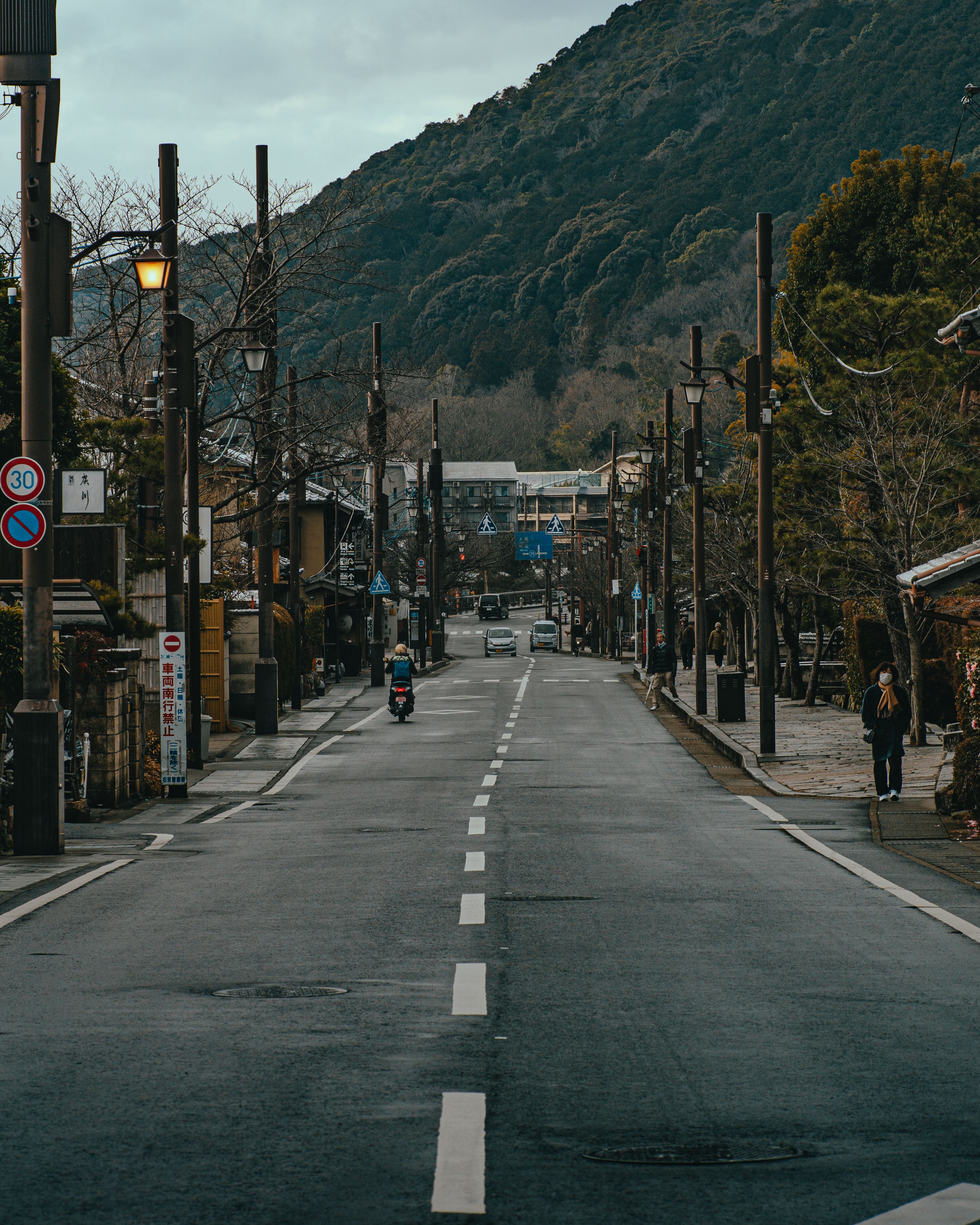 A tranquil city street leading to lush mountains, exuding urban serenity.