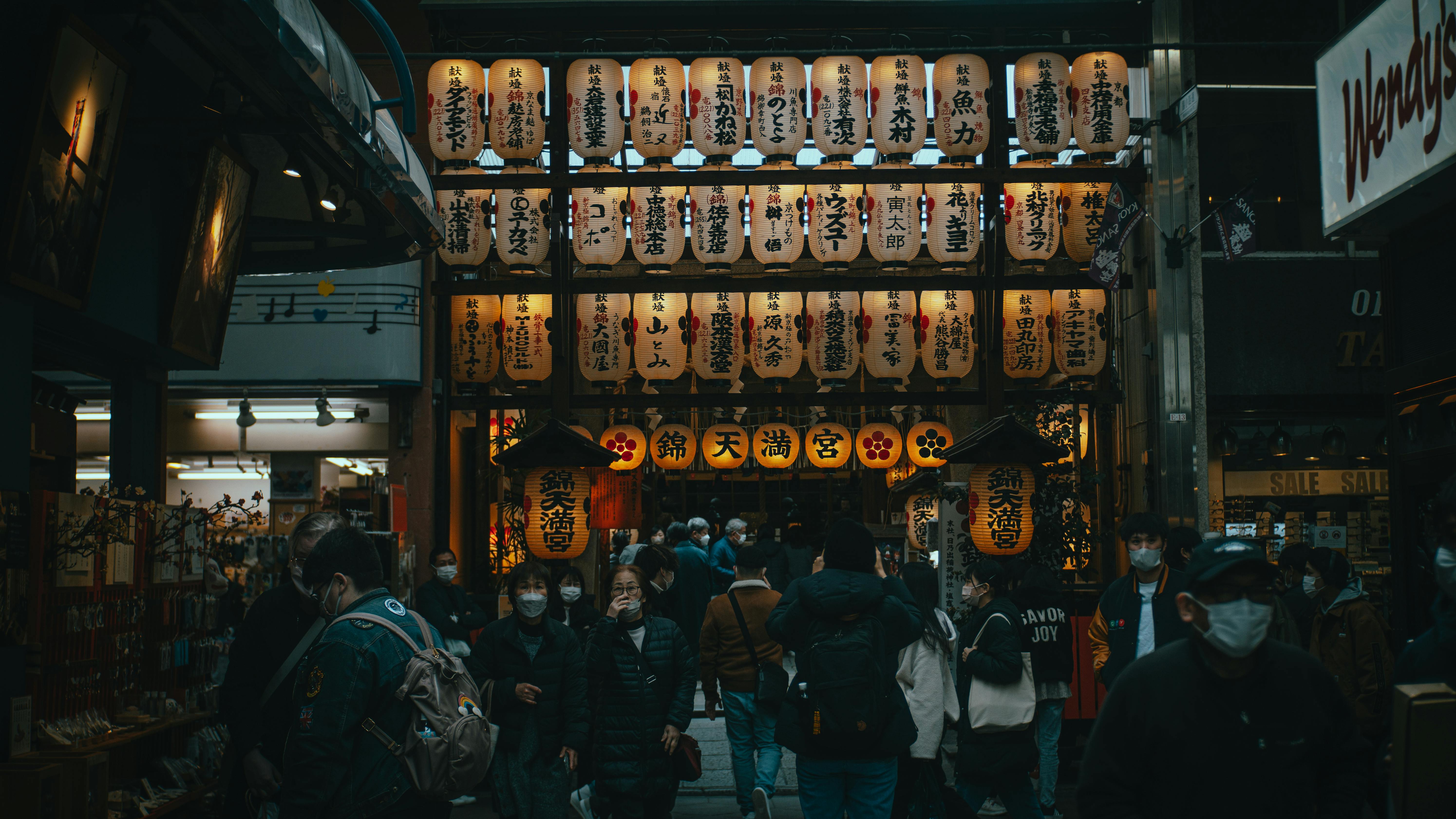 view of a crowd walking at the nishiki tenmangu shrine in kyoto japan