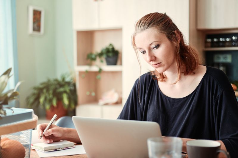 Person doing data entry and customer support chat on a laptop at a desk