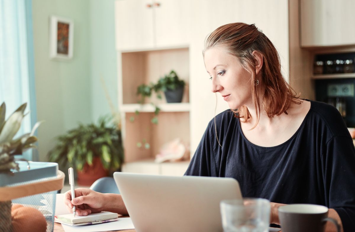 Friendly professional working at a tidy desk with laptop and documents