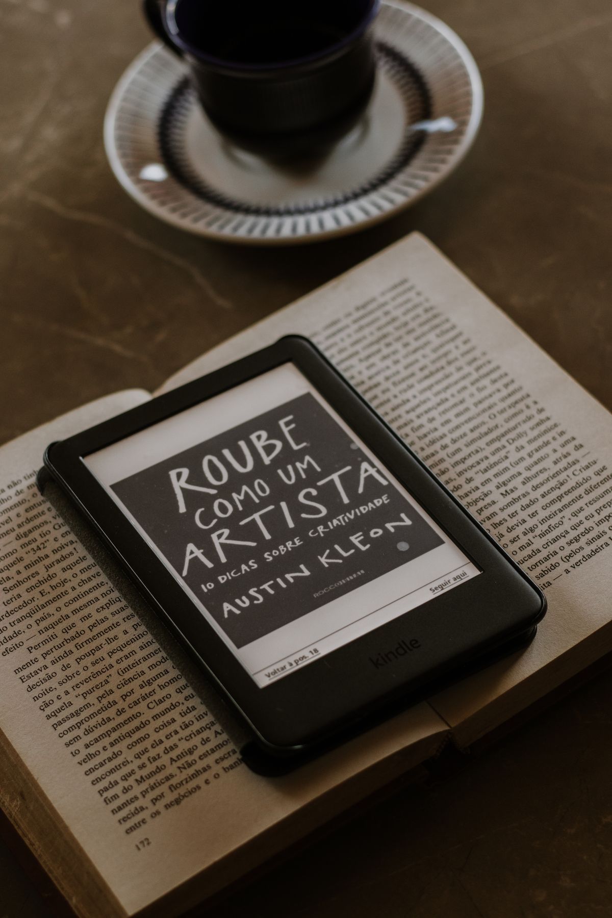 An e-reader resting on an open book