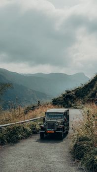 A rugged vehicle journeys through winding mountainous roads in Kottayam, Kerala, India.