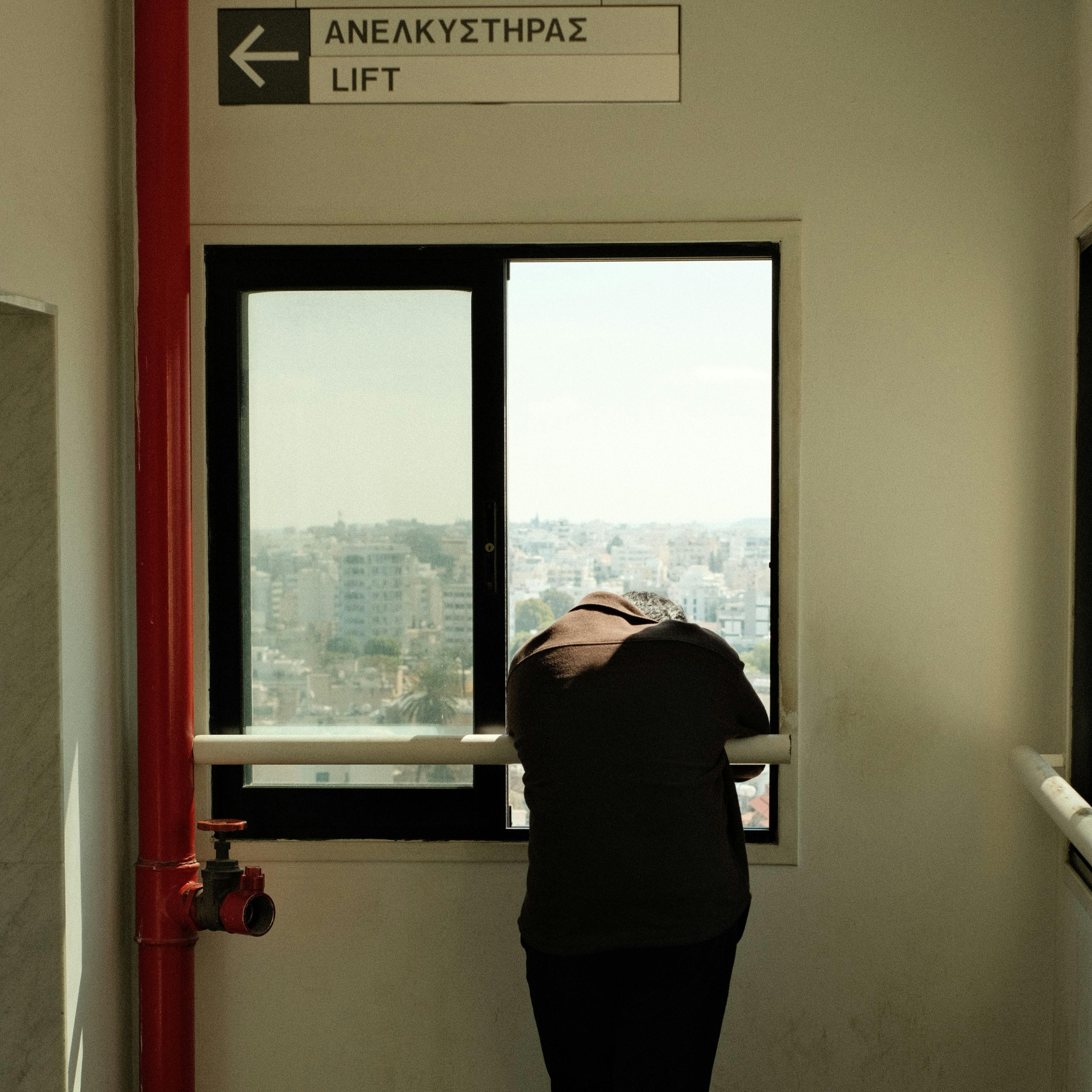 Person Looking through Open Window · Free Stock Photo