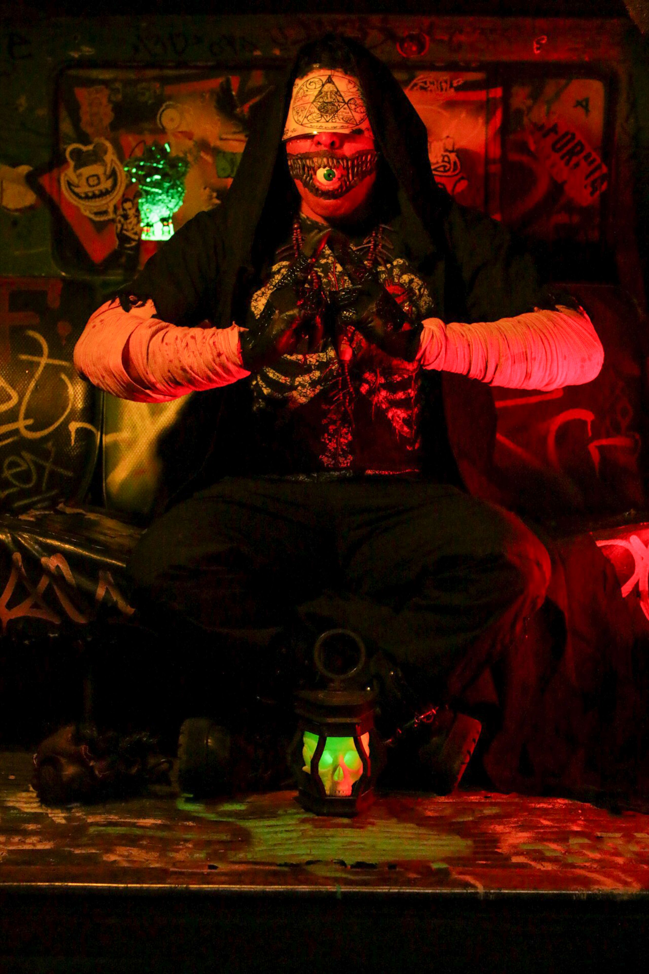 Person in Costume Sitting in Ritual in Darkness · Free Stock Photo