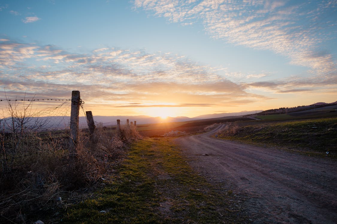 A dirt road leading to a sunset