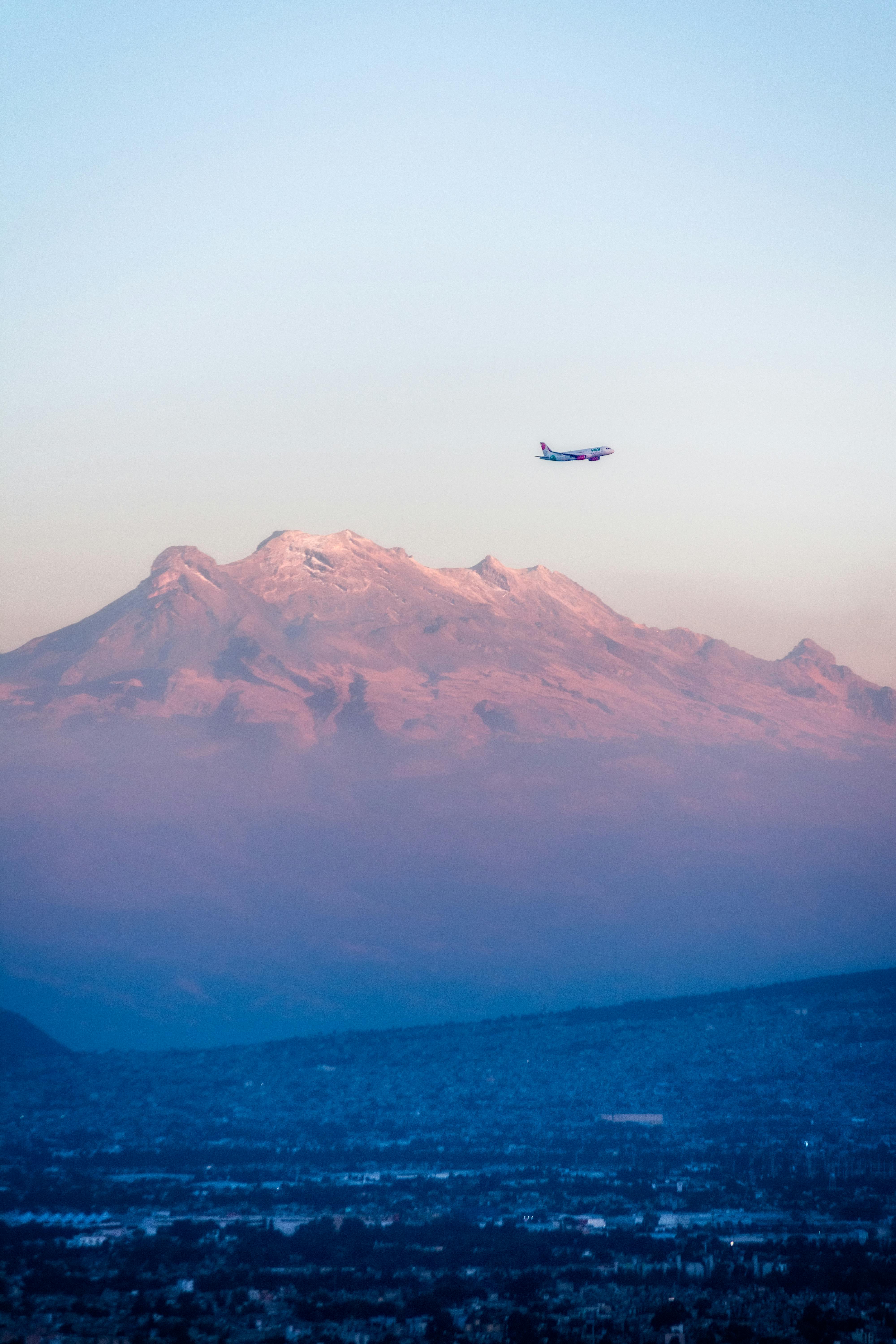 view of an airplane flying above iztaccihuatl in mexico at sunset