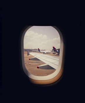 View of airplane wing and runway from window seat, perfect for travel themes.