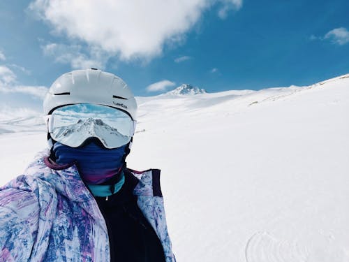 A person wearing a ski helmet and goggles on a snowy slope