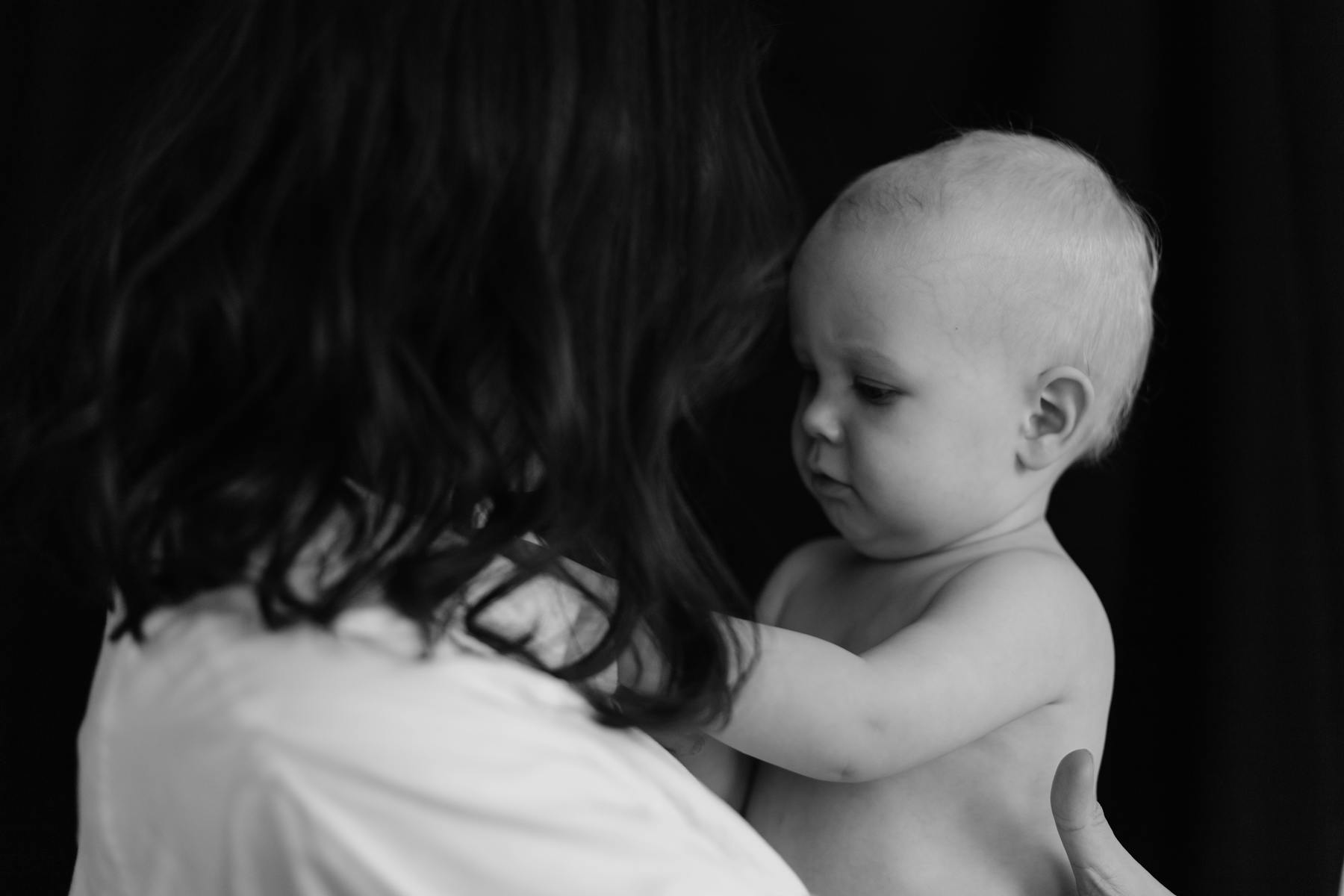 A mother holding her newborn baby, their closeness quiet and complete