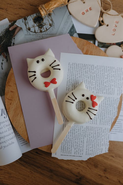 Cat Cake Pops Lying on Pieces of Paper on a Table 