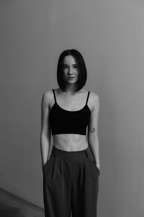 Black and White Photo of a Young Woman Wearing a Crop Top and Wide Leg Pants 