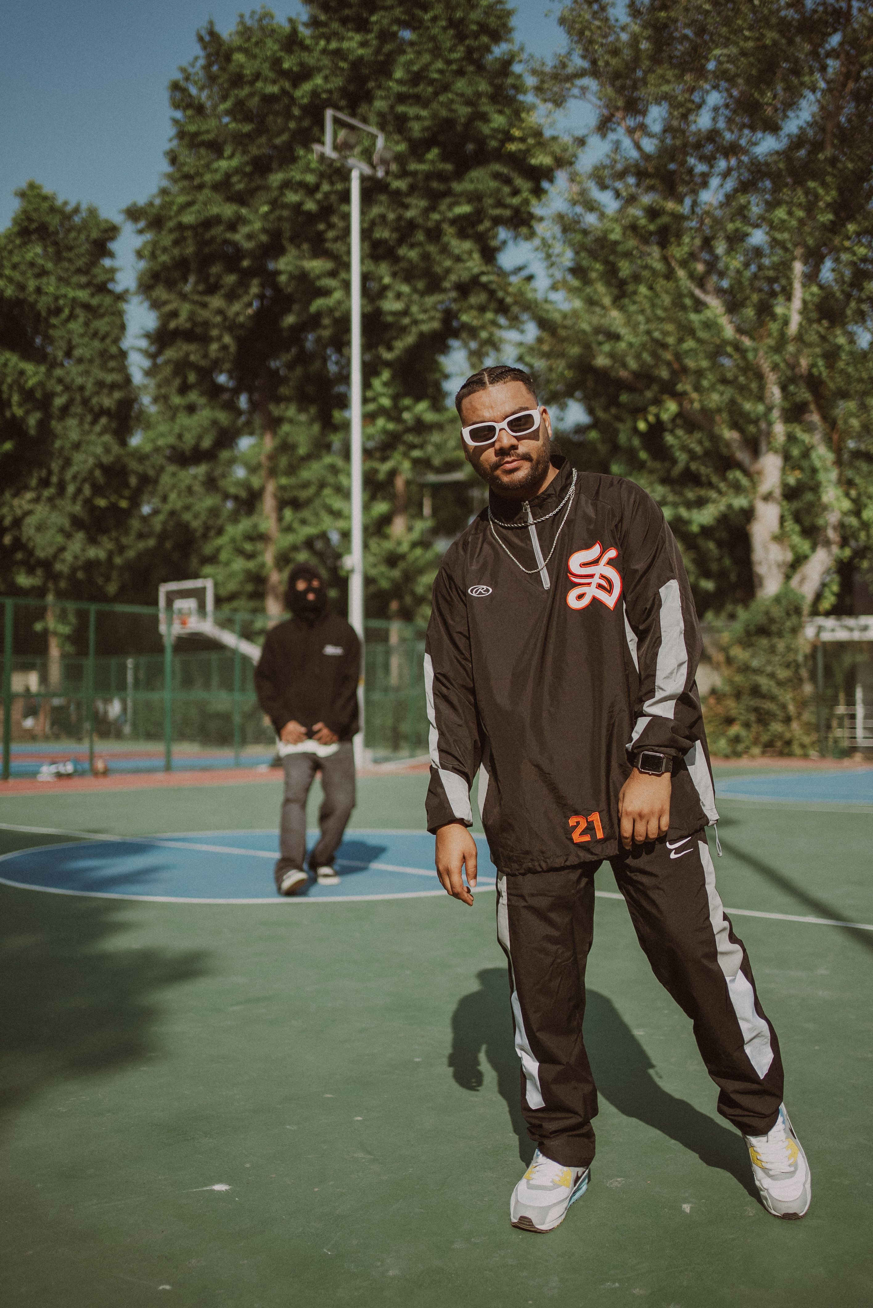 Stylish men on an urban basketball court in New Delhi, showcasing modern fashion and streetwear.