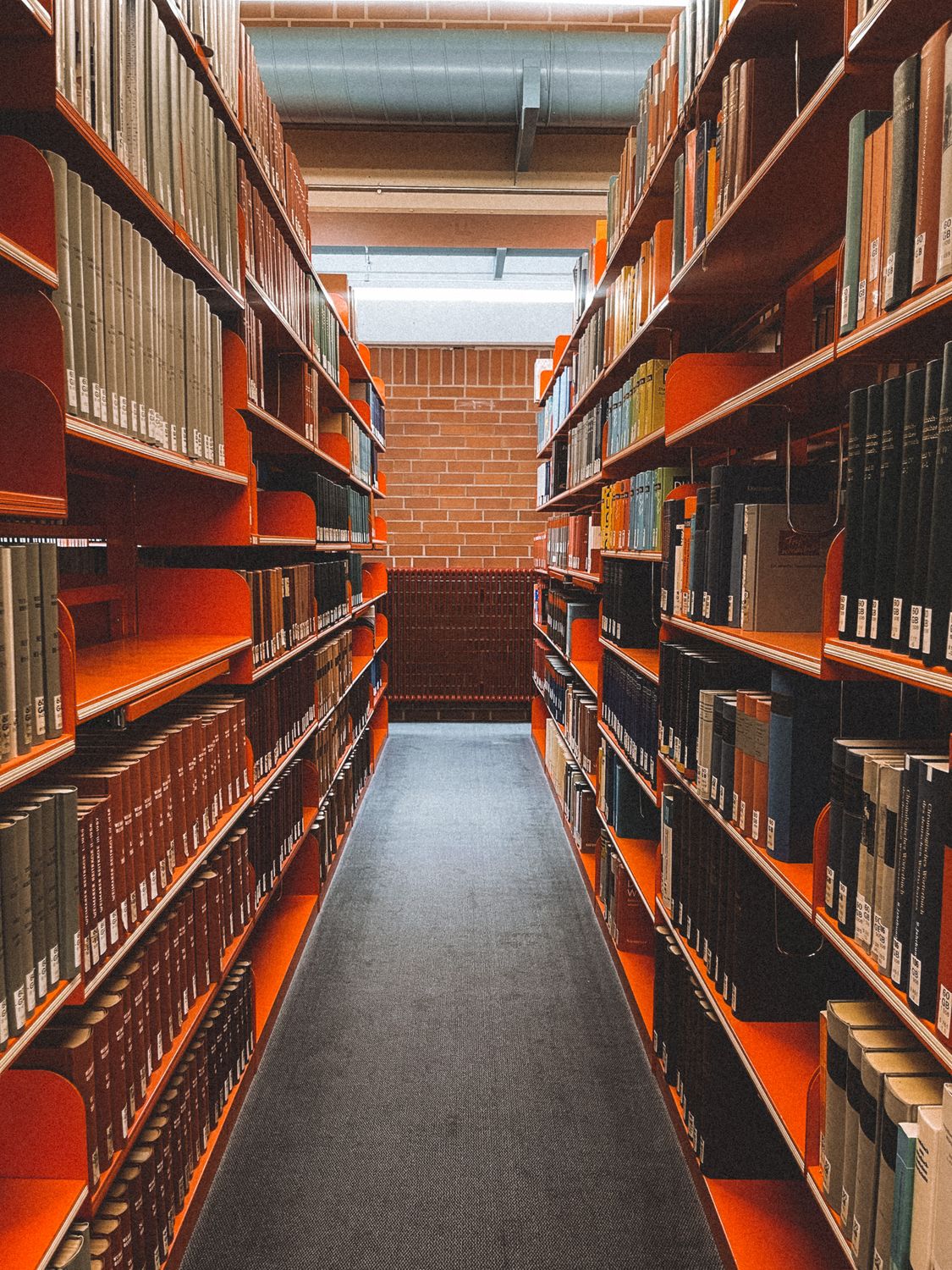 Library Text Vertical Symmetrical View of Bookshelves in a Library ยท Free Stock Photo
