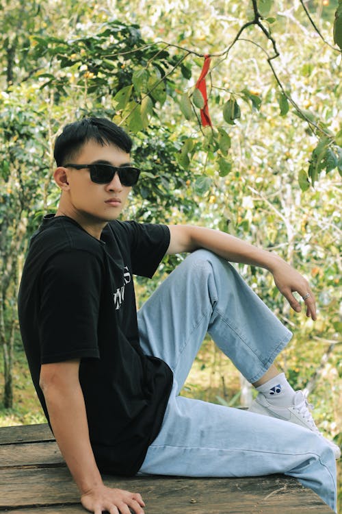 Man Sitting in Sunglasses and Black T-shirt