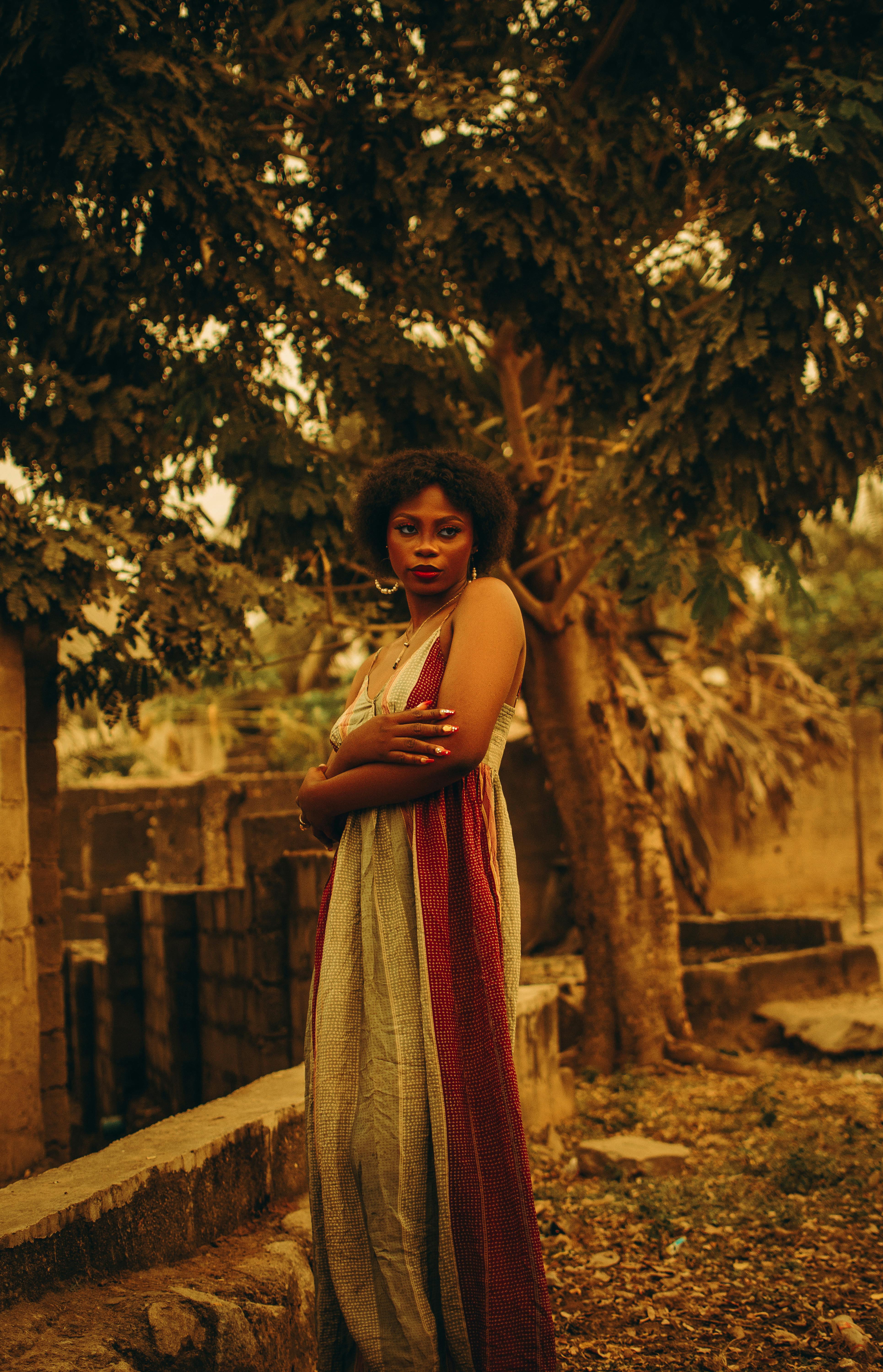 woman in dress standing with arms crossed